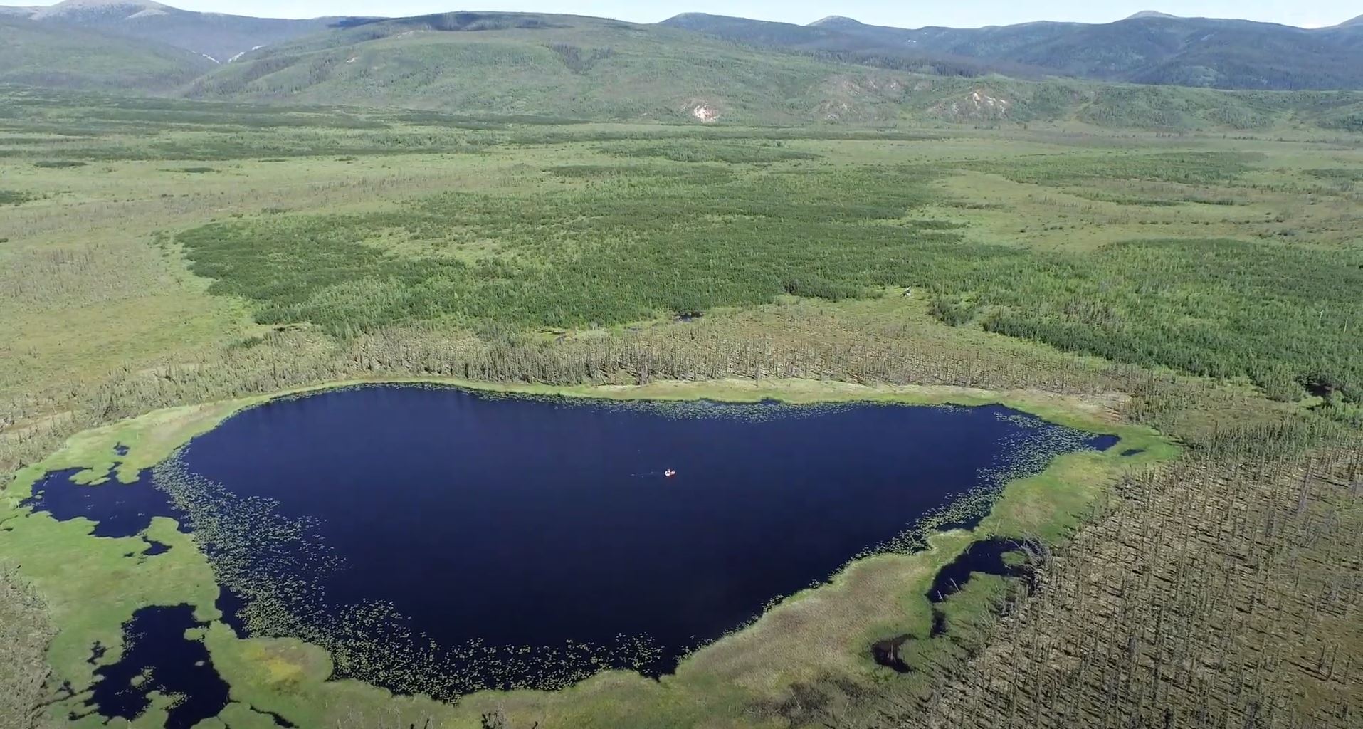 Aerial view of Flyby Lake, Alaska, with a coring raft visible on the water